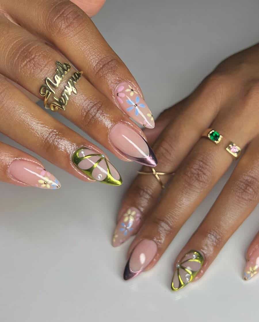 Medium almond nails with shiny nude polish, green chrome butterfly wings accents, pastel flower art, and purple chrome tips.