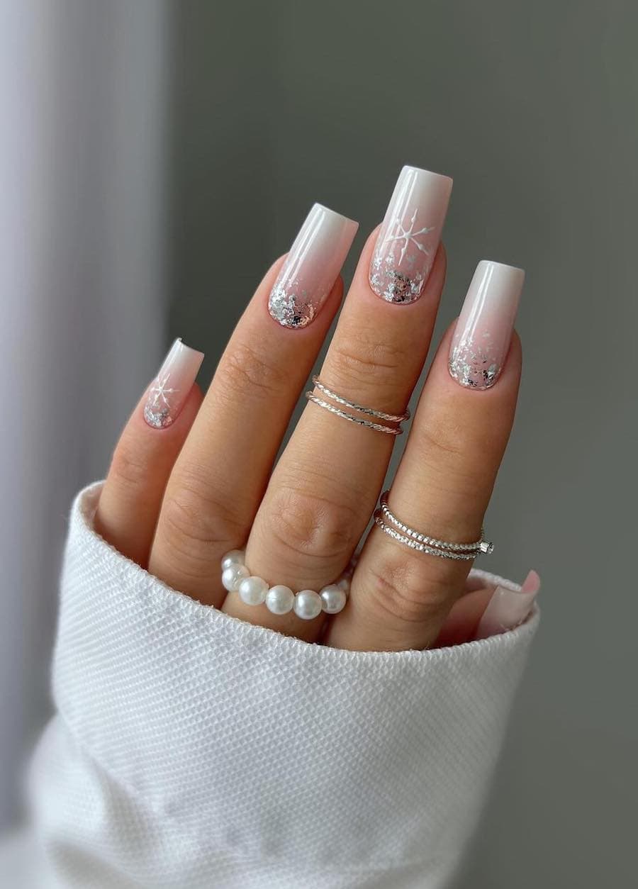 white and soft pink ombre nails with chunky silver glitter and white snowflake art