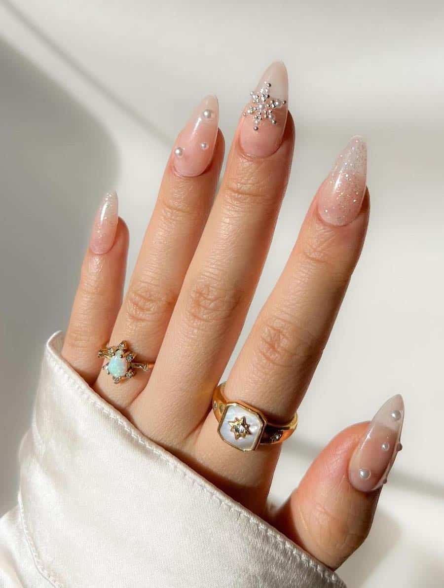 shimmering gold and nude nails with pearl holiday embellishments