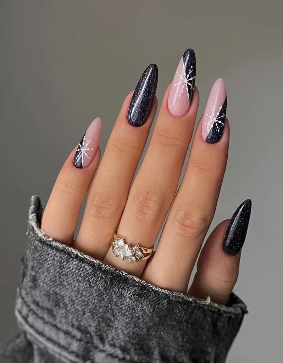 black glitter nails with nude pink accents and white snowflake art