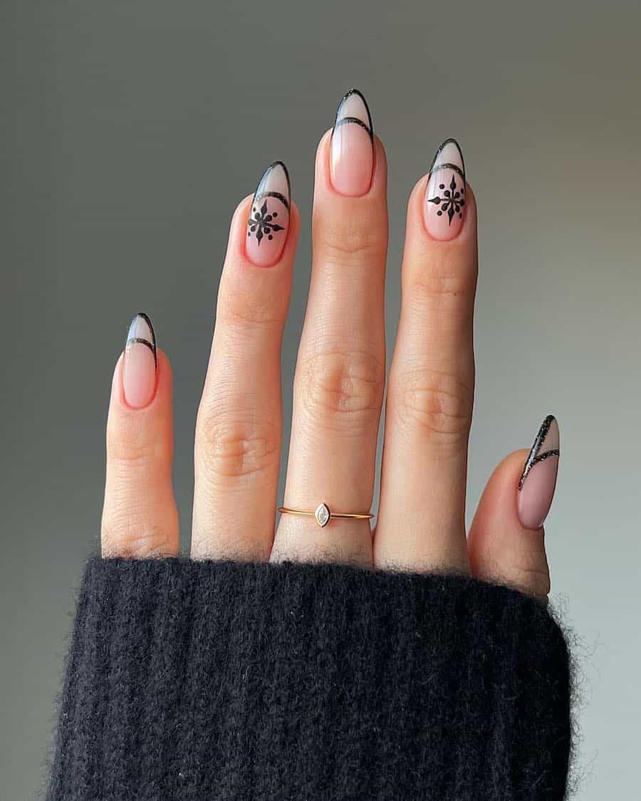 nude nails with black glitter tip outlines and snowflake art