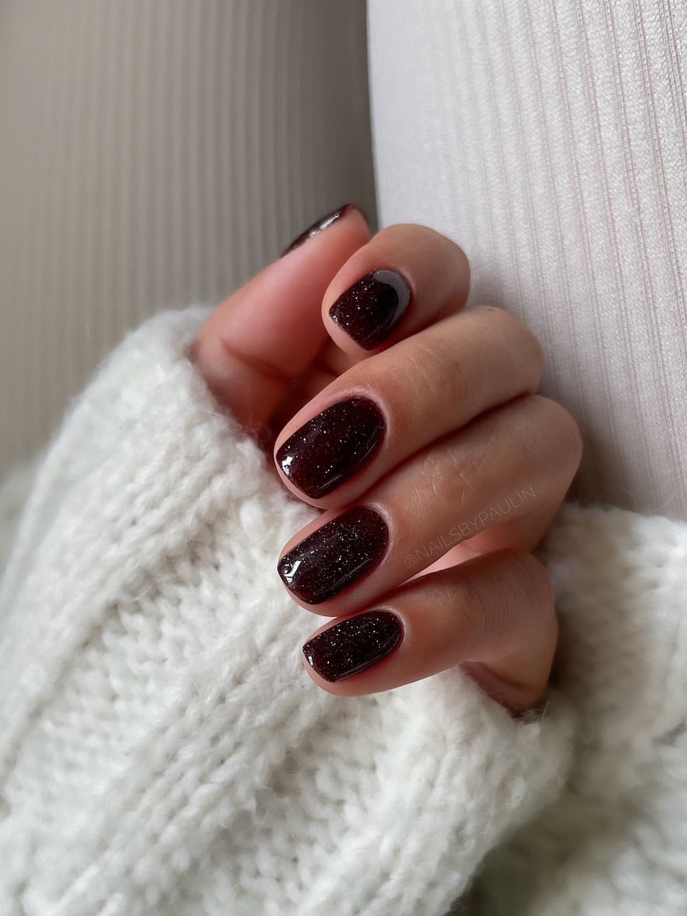 Short brown nails with a speckled white finish