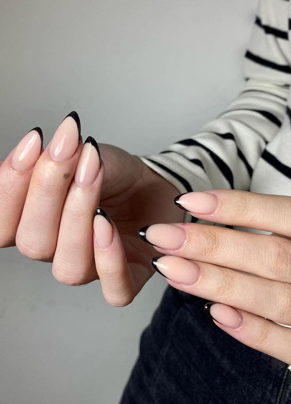 Short, bare almond nails with thin black tips