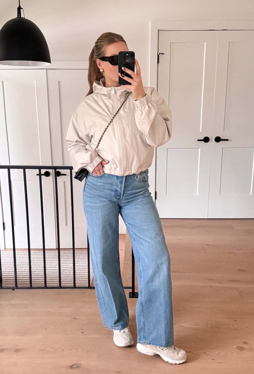 Christal wearing jeans with a wind breaker and New Balance sneakers.