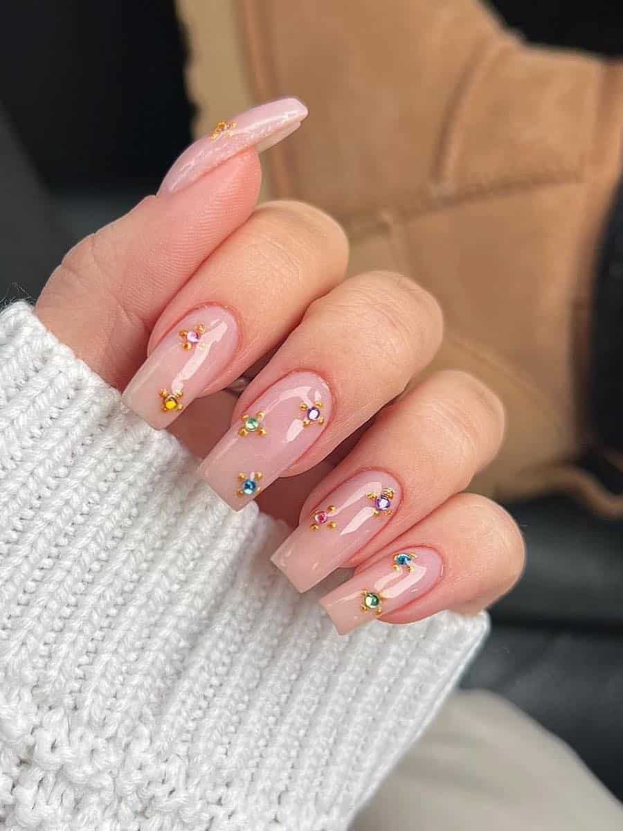 long nude square nails with colorful gemstone accents