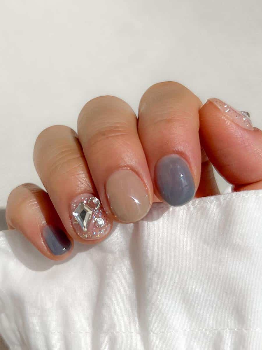 short beige and gray nails with gemstone accents