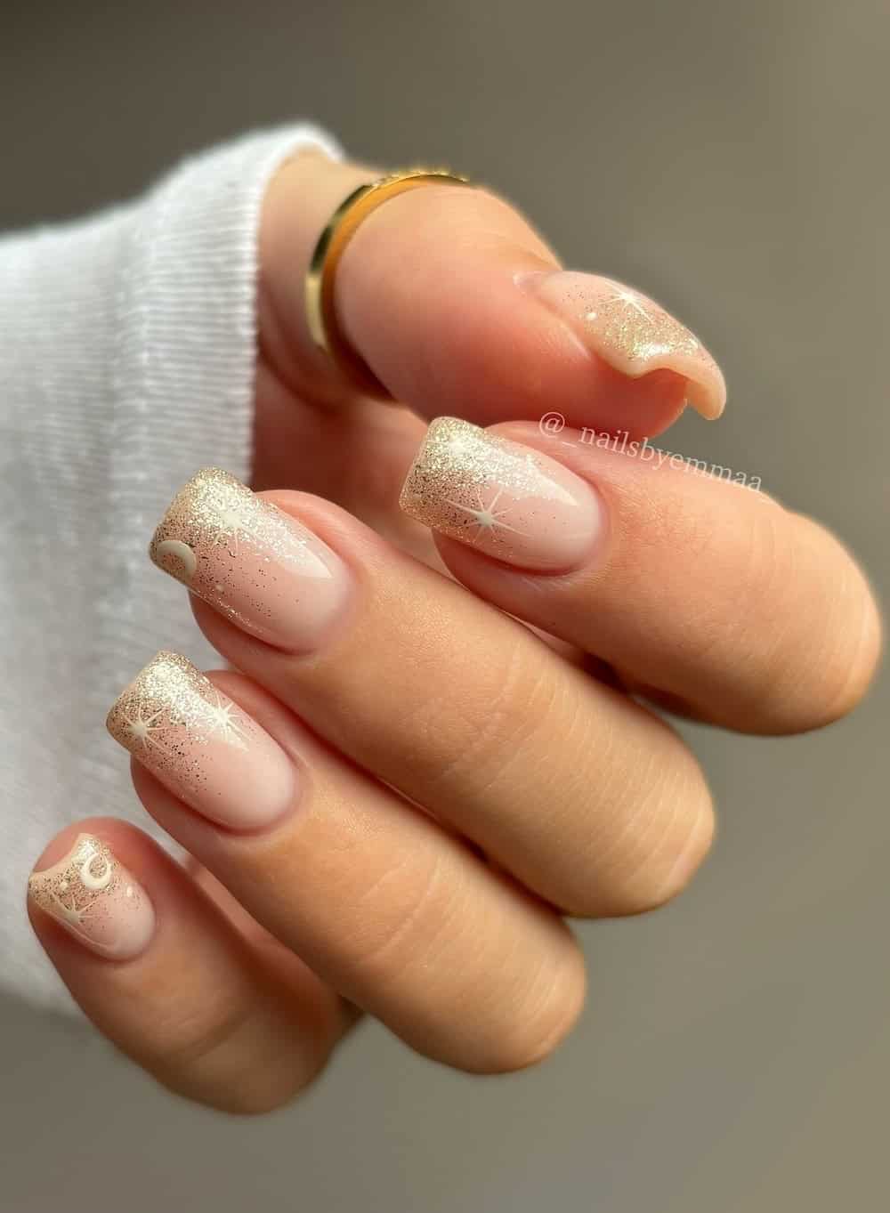 Medium nails with a shiny gold ombre and a white star and moon