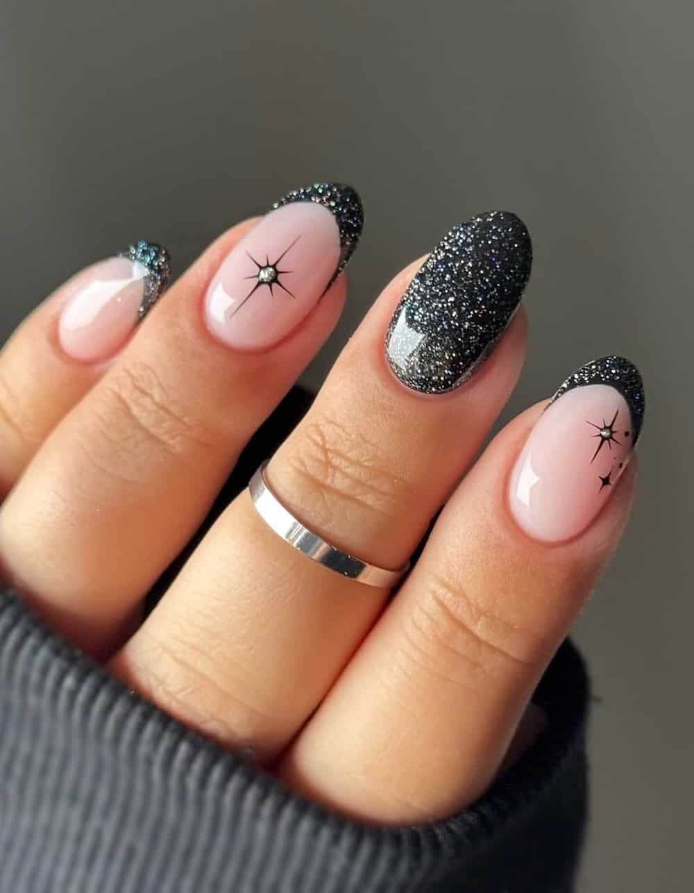 Short nude nails with shiny black polish and shiny accents