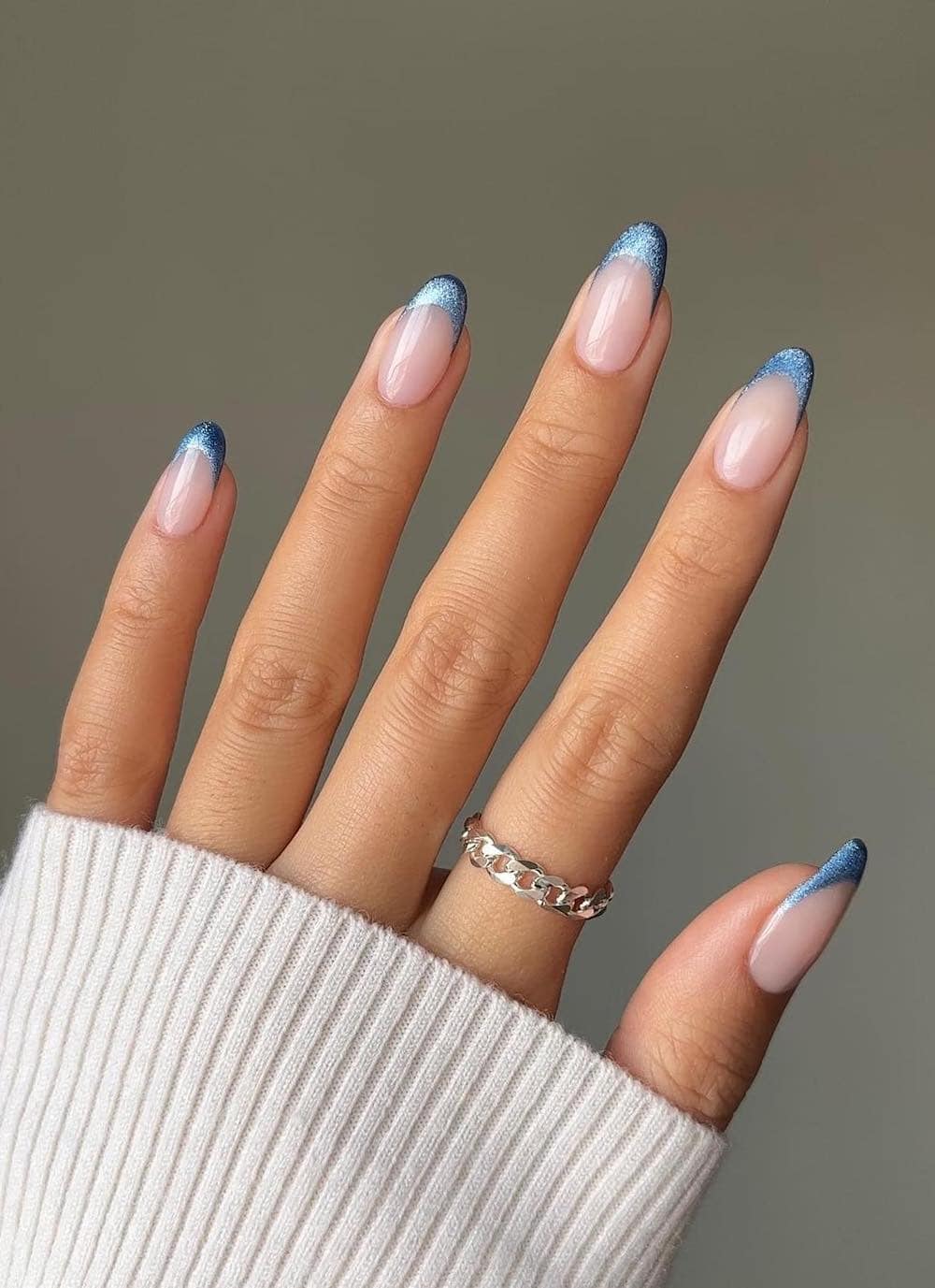 Long milky nude nails with sparkling blue tips