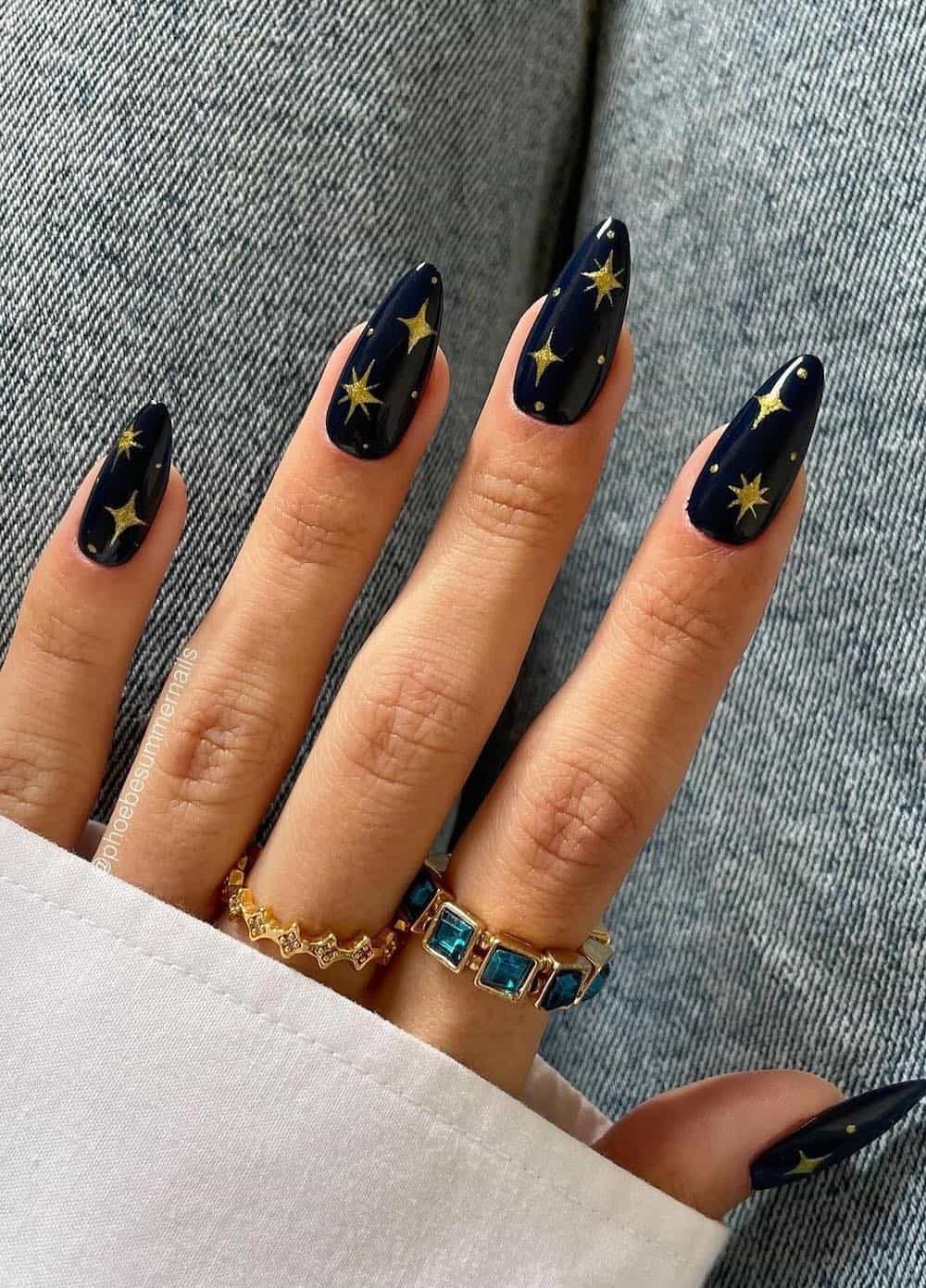 Long navy blue almond nails with gold star and glitter art