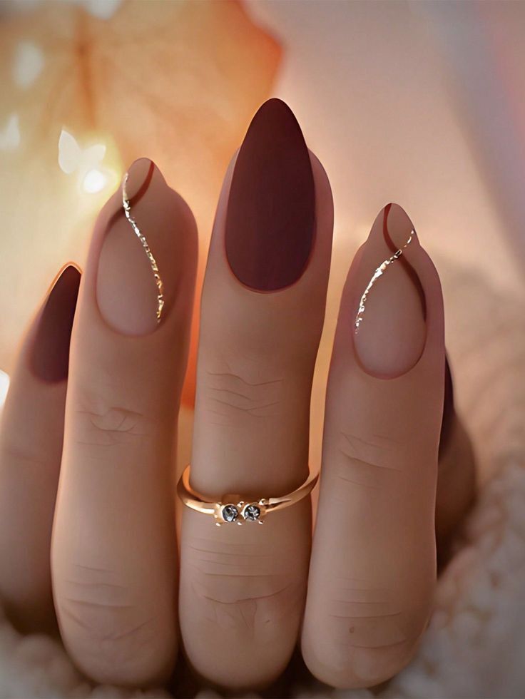 24. Elegant Burgundy and Nude Almond Nails with Gold Accents